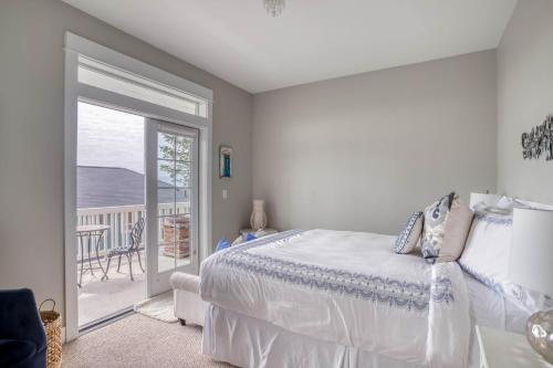 ein weißes Schlafzimmer mit Bett und Balkon in der Unterkunft Coral Crest in Lincoln City