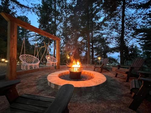 a fire pit in the middle of a yard with benches at Glamping Puertecillo Surf & Camp in Puertecillo