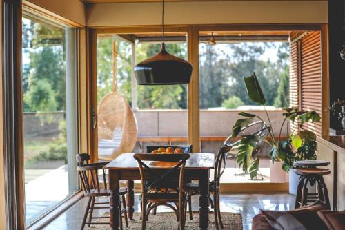 a dining room with a table and chairs and a window at Luxury Retreat at Barham Avocados in Barham