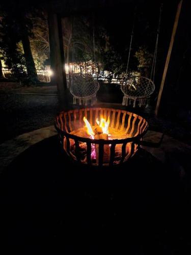 a fire pit at night with two chairs around it at Glamping Puertecillo Surf & Camp in Puertecillo