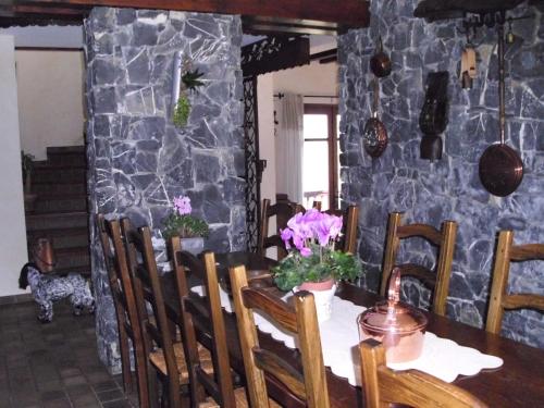 une salle à manger avec une table et un mur en pierre dans l'établissement Demeure d'hôtes Les Irisynes, à Viviers-du-Lac