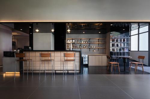 a restaurant with a bar with chairs and a table at Xiamen Desti Youth Park Hostel Zhongshan Road in Xiamen