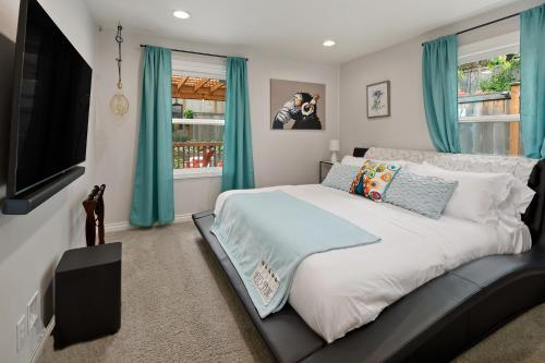 a bedroom with a large bed with blue curtains at Blue Oasis with Amazing Olympic Views in Seattle