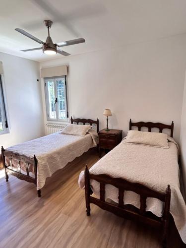 a bedroom with two beds and a ceiling fan at Al Puente y Palo - Casa de Piedra in San Lorenzo