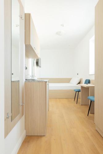 a kitchen with white walls and wooden cabinets at Millennia Hotel in Sofia