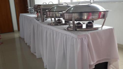 a row of tables with white table cloths at Hotel Catama Inn in Fusagasuga