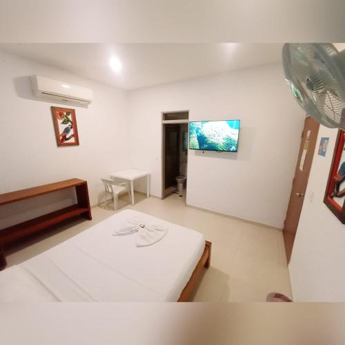 a room with a bed and a table and a tv at Hotel el Tesoro in Puerto Boyacá