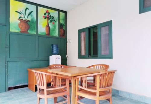 a dining room with a wooden table and chairs at Hotel Grand Astoeti in Kopo 2
