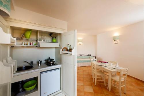 a kitchen and dining room with a table and chairs at Relaxing Residence Baia dei Mirti B4 1 Bedroom Apartment Sleeps 4 -Bilo 4 in Vignola Mare