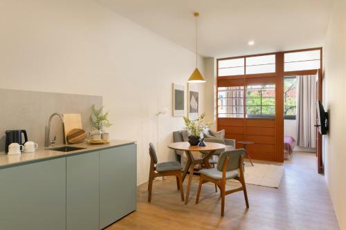 a kitchen and living room with a table and chairs at Alma House in Singapore