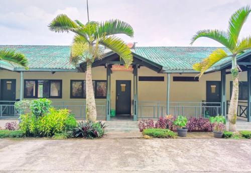 a building with two palm trees in front of it at Hotel Grand Astoeti in Kopo 2