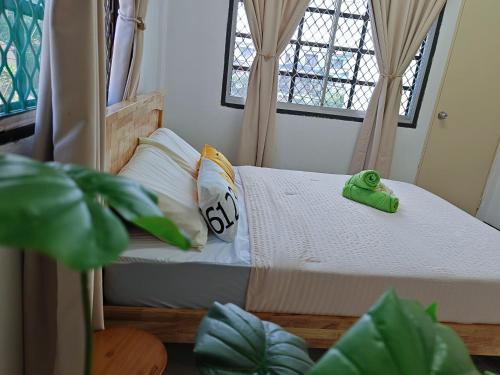 a small bedroom with a bed and two windows at Kluang Budget Home in Kluang