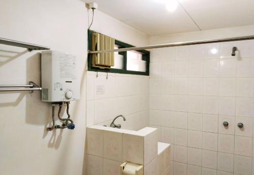 a bathroom with a sink and a shower at Hotel Grand Astoeti in Kopo 2