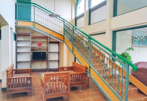 a stairway in a building with wooden benches at Hotel Grand Astoeti in Kopo 2