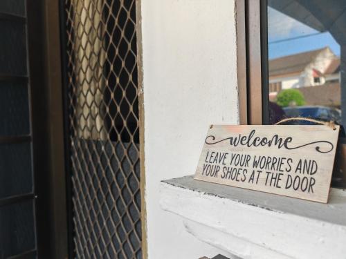 a welcome sign on the window of a door at Kluang Budget Home in Kluang
