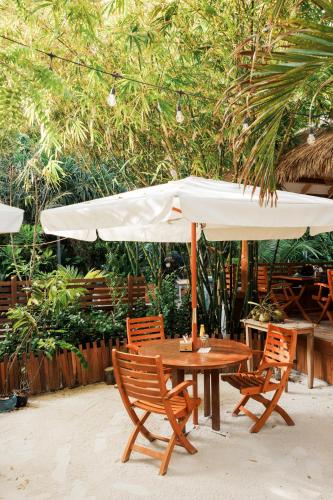 a table and two chairs and an umbrella at Ostrov Beach in Ukulhas