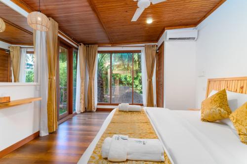 a bedroom with a white bed and a large window at Ostrov Beach in Ukulhas