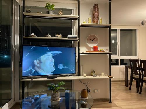 Un televisor con un hombre con sombrero en la pantalla. en Cómodo depto concón, en Concón