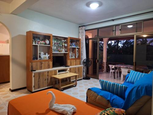 a living room with a blue couch and a table at Belle Maison F3 in Papeete