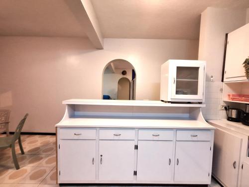 a white dresser with a mirror in a kitchen at Belle Maison F3 in Papeete
