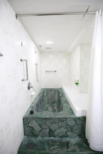 Un baño con bañera con suelo de piedra. en Hotel Asia Cebu, en Cebú