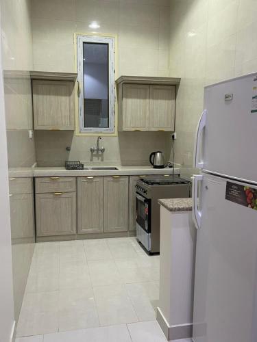 a kitchen with a white refrigerator and a sink at الدانه 2 in Hafr Al-Batin