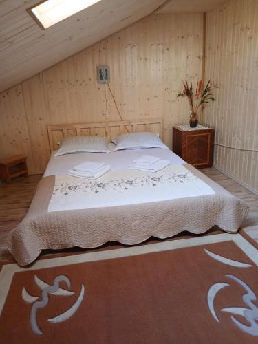 a bedroom with a large bed in a attic at Pensiune Colina Farm in Găgeni