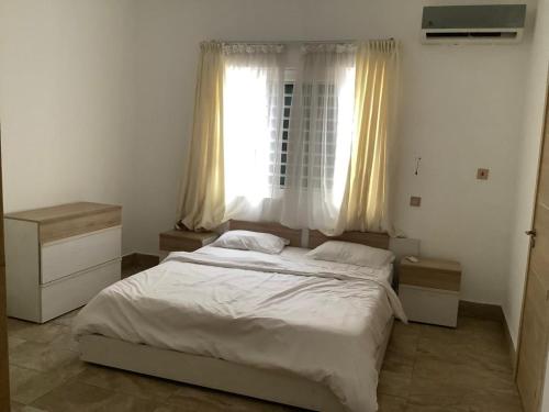 Un dormitorio con una cama grande y una ventana. en Luxurious 2 Bedroom Apartment, en Accra