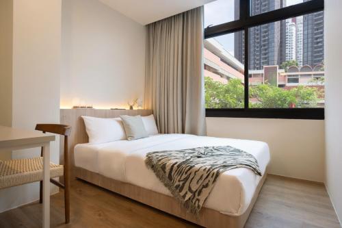 a bedroom with a bed and a large window at Alma House in Singapore