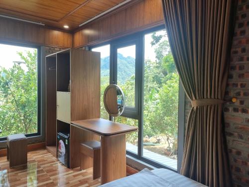 a bedroom with a mirror and a bed and a window at Trường Anh Homestay Hà Giang in Ha Giang