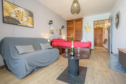 una sala de estar con un sofá y una mesa en Le Flamboyant - Balcon vue mer - Wiskeys, en Saint-Gilles-les-Bains