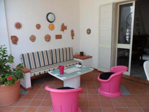 a living room with a table and two pink stools at villa marisa by salentolimit in Torre Lapillo