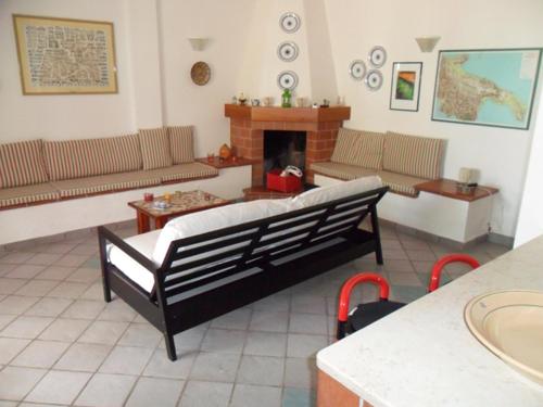 a living room with a couch and a fireplace at villa marisa by salentolimit in Torre Lapillo
