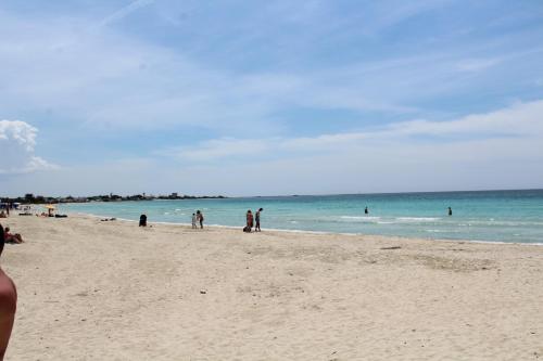 a group of people walking on the beach at villa marisa by salentolimit in Torre Lapillo