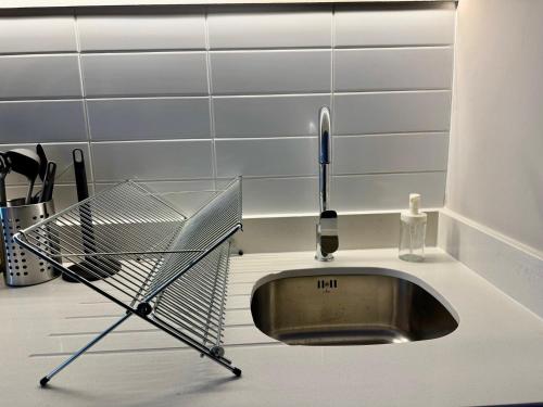 a metal dish drying rack next to a sink at HOM I Lujoso Depto 2D2B, Ñuñoa con Estacionamiento in Santiago