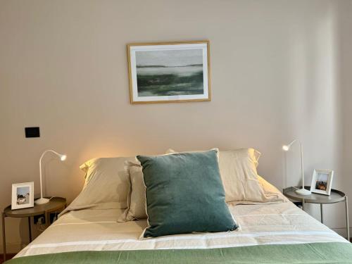 a bed with a green pillow on top of it at HOM I Lujoso Depto 2D2B, Ñuñoa con Estacionamiento in Santiago