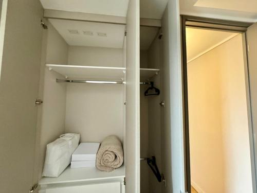 a walk in closet with white towels and a mirror at HOM I Lujoso Depto 2D2B, Ñuñoa con Estacionamiento in Santiago