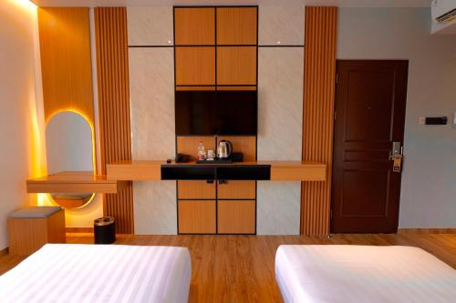 a hotel room with two beds and a kitchen at Eagle Hotel Wonosobo, Azana Hotels Collection in Kalianget