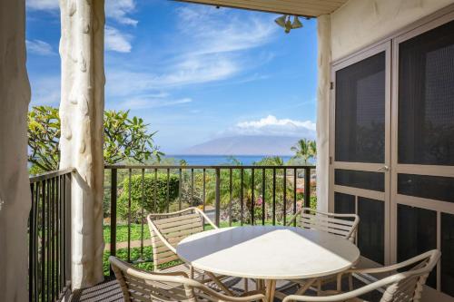 a table and chairs on a balcony with a view of the ocean at Aston Maui Hill in Wailea