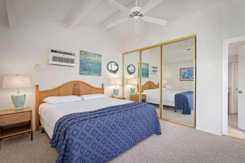 a bedroom with a bed and a large mirror at Aston Maui Hill in Wailea