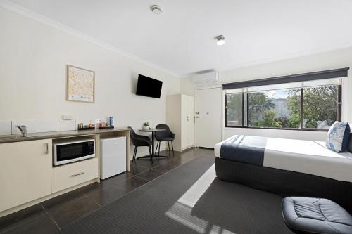 a bedroom with a bed and a kitchen with a table at Hamilton Lakeside Motel in Hamilton