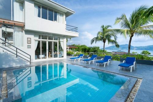 a villa with a swimming pool and blue chairs at Vipa Seaview Villa in Patong Beach