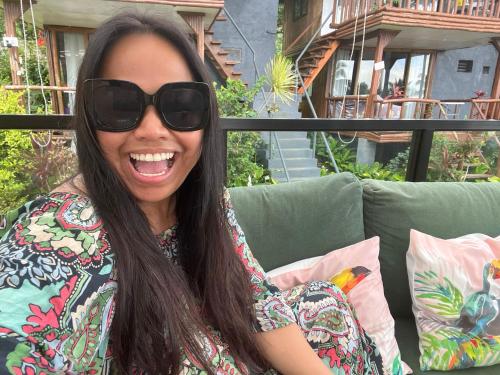 a woman wearing sunglasses sitting on a couch at Bintana sa Paraiso Binunsaran in Mambajao