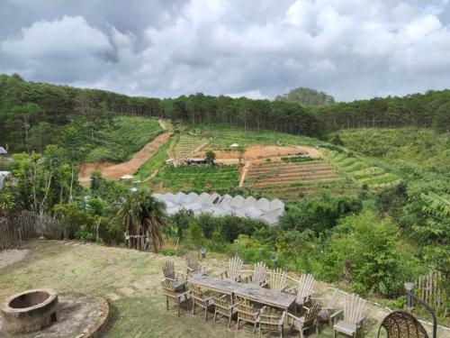 a garden with a table and chairs on a hill at Lưng Chừng House in Da Lat