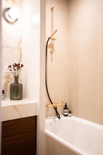 La salle de bains est pourvue d'une douche, d'une baignoire et d'un lavabo. dans l'établissement Superbe Appartement Toulouse hypercentre, à Toulouse