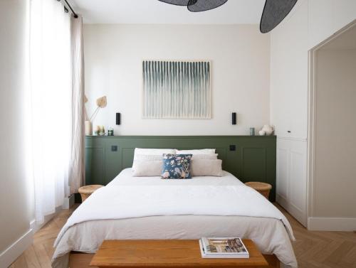 une chambre avec un grand lit avec une tête de lit verte dans l'établissement Superbe Appartement Toulouse hypercentre, à Toulouse