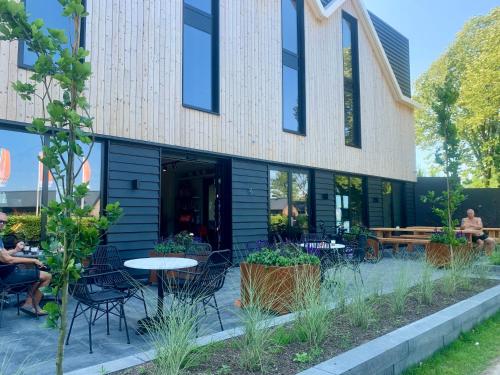 a building with a table and chairs in front of it at Tiny Haus Auszeit am See in Lathum