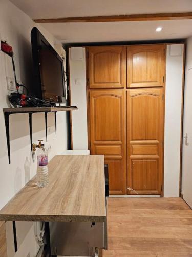 une pièce avec une table avec une télévision et une porte en bois dans l'établissement studio, à Saint-Nazaire