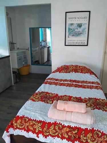 a bed with two towels sitting on top of it at SUNSETVIEW, studio, private beach, amazing swim & sunset in Haapiti