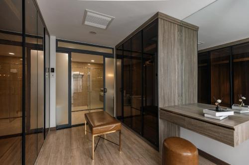 a bathroom with a vanity with a chair and a shower at Luxhome Mekong Hotel in Can Tho